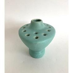 a blue ceramic vase with holes in the middle