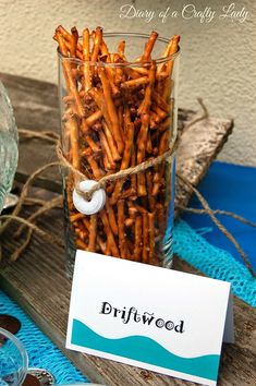 a jar filled with fries sitting on top of a wooden table next to a sign