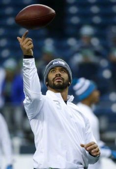 a man throwing a football on top of a field