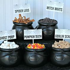 a table topped with black caulders filled with halloween treats