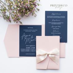 the wedding stationery is laid out on top of pink envelopes and blue cards