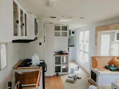 the inside of a house being remodeled with wood flooring and white walls, including cabinets