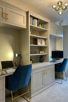 a home office with blue chairs and white cabinets