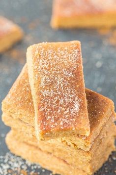 several pieces of sugary brownies stacked on top of each other with powdered sugar