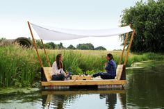 two people sitting on a floating picnic table