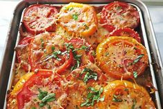 a pan filled with sliced tomatoes and herbs