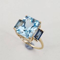 This stunning ring is set in 14k Solid Yellow Gold with Natural Sky Blue Topaz & London Blue Topaz with utmost precision. It is an unique statement gemstone ring for nearly every occasion and is completely hassle-free jewelry. ITEM DETAILS * CENTER GEM: Sky Blue Topaz * GEM SIZE: 10X12mm * GEM SHAPE: Octagon (Emerald Cut) * GEM WEIGHT: 7.35 carats * SIDE GEM: London Blue Tooaz * GEM SIZE: 3x6mm (2pc) * GEM SHAPE: Baguette * GEM WEIGHT: 0.75 carats * Total GEM WEIGHT: 8.10 carats * Gold Purity: 1 Sky London, Jewelry 2024, Sky Blue Topaz Ring, Gold Skies, Blue Topaz Jewelry, Teal Sapphire, Sophisticated Bride, Topaz Jewelry, London Blue Topaz Ring