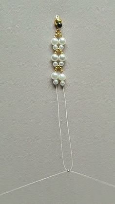 a white and gold necklace hanging from the ceiling