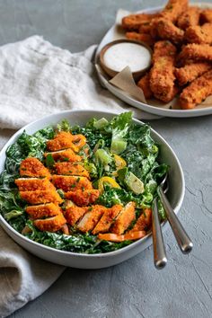 two bowls filled with food next to each other on top of a white table cloth