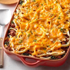 a red casserole dish filled with pasta and cheese