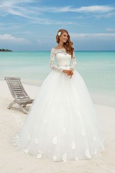 a woman in a wedding dress standing on the beach