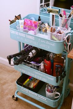 a blue cart filled with lots of makeup and personal care items sitting on top of a carpeted floor