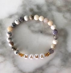 Our Mama Bracelets make a perfect gift for any mama in your life. Looks great paired with our Gold Ball Beaded Bracelet. Make it more meaningful with a Custom Name Bracelet and personalize with a name or initials! This bracelet is made with high quality elastic. This bracelet stretches to fit most wrists and is approximately 6.5-7" in length. Details:- White Beads with Gold Lettering "MAMA"- Opal Beading + golden accents- Stretches to fit most wrists approximately 6.5-7" in length. Your jewels w Cheap White Stretch Bracelet For Mother's Day, New Mum Bracelet, Mama Bracelet, Gold Lettering, Name Bracelet, A Name, White Beads, Bracelet Gift, Custom Name