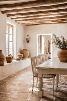 a dining room table with chairs and vases on it