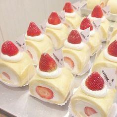 there are many small desserts on the table with strawberries in them and tags attached to them