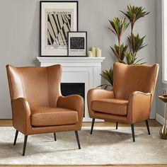 two brown chairs sitting next to each other in front of a fireplace