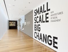 an empty room with white walls and black lettering on the wall that says small scale big change