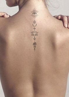 the back of a woman's neck with tattoos on her upper and lower back