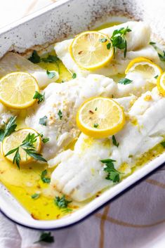 fish with lemons and parsley in a baking dish