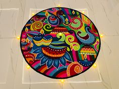 a colorful painting on the floor with lights around it