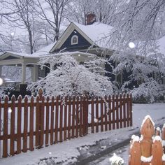 a house with snow on the roof and fence