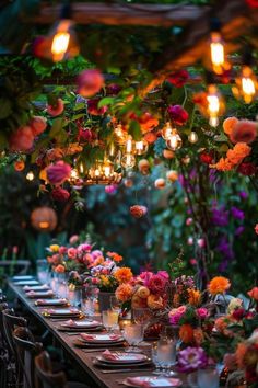 a long table with flowers and candles on it is set up for an outdoor dinner