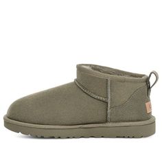 The UGG Classic Ultra Mini Boot in Moss Green offers a sleek and modern take on the classic UGG style. Crafted from premium suede and lined with cozy sheepskin, this boot provides both comfort and style. Its low-cut design makes it easy to slip on and off, perfect for casual wear. The rich moss green color adds a touch of earthy elegance to any outfit. Green Mini Uggs, Green Uggs Boots Outfit, Green Ugg Boots, Green Uggs, Uggs Mini, Ugg Green, Ultra Mini Ugg, Moss Green Color, Wishlist Christmas