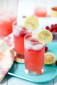 two glasses filled with watermelon lemonade and raspberry punch on a blue plate