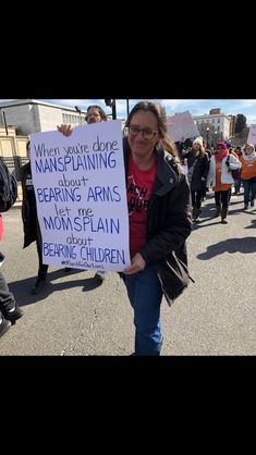 a woman holding a sign that says when you're doing mansplaning about bearing arms, momsplant about being children