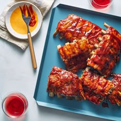 barbecue ribs on a blue plate with sauces and ketchup next to them