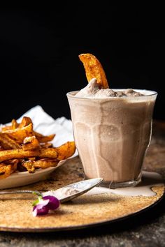 a plate with some fries and a drink on it