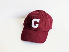 *CUSTOM LETTER BASEBALL HAT* MAROON/BURGUNDY adjustable youth baseball cap with a custom white applique initial on the front! *ONE SIZE* Adjustable Buckle Strap FITS HEADS 19-23 INCHES IN CIRCUMFERENCE Ideal for 3 to 10 years old, on average. *FEATURES* 100% Soft Cotton Adjustable Buckle Strap Soft Inner Lining Sweat Band Well Ventilated Cotton Fabric Lightweight College Baseball Cap For Baseball Season, College Baseball Season Cap With Visor, College Baseball Season Visor Cap, College Baseball Season Cap, Collegiate Baseball Cap With Curved Brim For Baseball Season, College Baseball Cap With Curved Brim And Letter Print, College Baseball Cap With Letter Print And Curved Brim, Collegiate Snapback Hat With Letter Patch And Curved Brim, Collegiate Snapback Hat With Curved Brim And Letter Patch