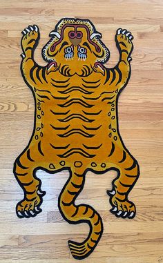 a wooden floor with a drawing of a tiger on it's back and arms in the air