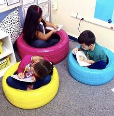 three children are sitting on bean bags in an office cubicle, while one child is reading