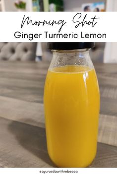 a glass jar filled with orange juice sitting on top of a wooden table