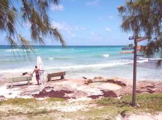 a man holding a surfboard next to the ocean