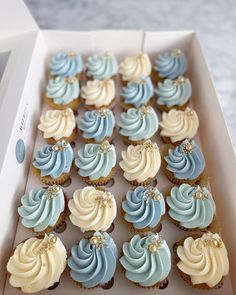 a box filled with blue and white cupcakes