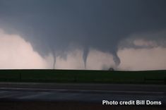 a large tornado is in the sky over a field