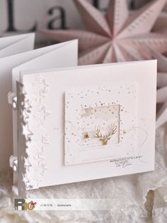 two white cards with gold foil on them and some snowflakes in the background