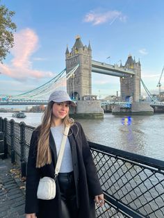 a woman standing in front of the tower bridge