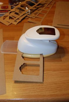 a computer mouse sitting on top of a wooden table next to some cut up pieces of paper