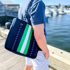 The Navy Courtside Pickleball Tote with Green and White Stripes is a preppy and functional bag that will become your go-to companion on and off the court. Whether you're a beginner or a seasoned player, this stylish pickleball bag is the ideal accessory to elevate your game. Our goal was to create the best pickleball bag for women, and we achieved it by designing this versatile tote that is turning heads on and off the court. It boasts several compartments and pockets, providing a hassle-free wa Navy Sporty Bag For Everyday Use, Sporty Navy Bag For Everyday Use, Sporty Navy Bag For Everyday, Navy Sporty Bag For Daily Use, Navy Rectangular Sporty Bag, Navy Sporty Rectangular Bag, Sporty Navy Rectangular Bag, Sporty Navy Bags For Outdoor Activities, Pickleball Bag