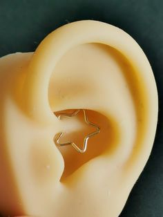 a close up of a person's ear with a star shaped object in the middle