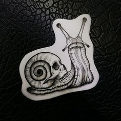 a sticker with a snail and a human skull on it's back side