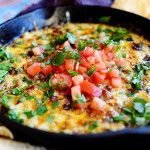 a black pan filled with food next to tortilla chips and a purple towel