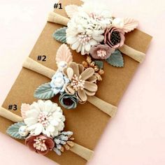 three flower headbands on top of a brown paper bag