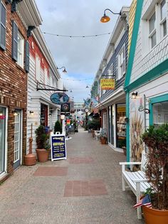 an empty street lined with shops and buildings on either side of the road is a sign that says,