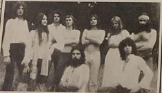 an old black and white photo of people posing for a group shot with long hair