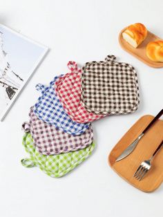 four pieces of cloth sitting on top of each other next to a knife and fork