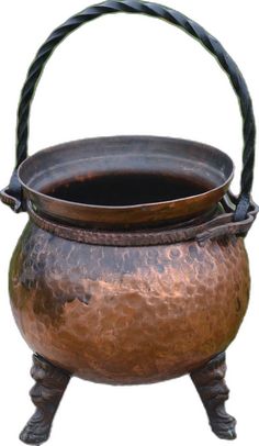 an old metal pot with a handle and rope on the bottom, sitting on a white background